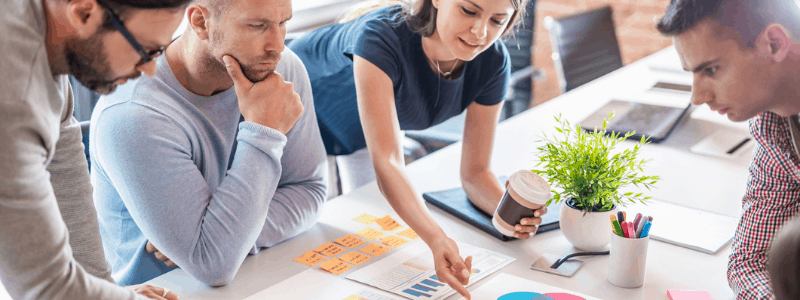 Das Team arbeitet an einem Tisch zusammen, um eine Analyse vor der Kampagne durchzuführen.