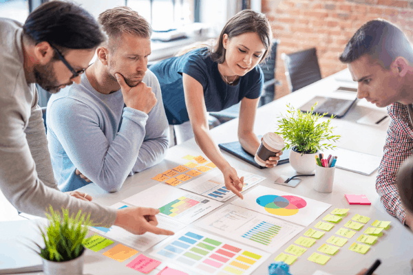 Team collaborating on a table conducting a pre-campaign analysis