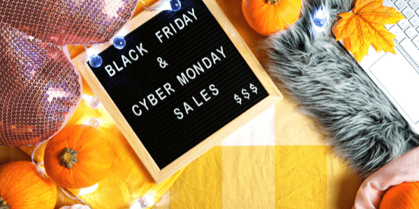 Fall-themed table with pumpkins and a letter sign titled Black Friday and Cyber Monday Sales.