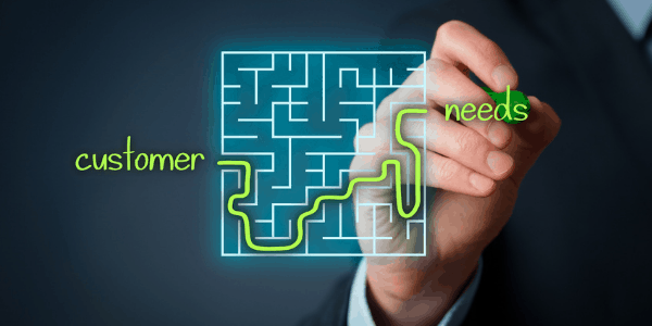 A man draws a line through a maze, with one end being customer to the other end being needs