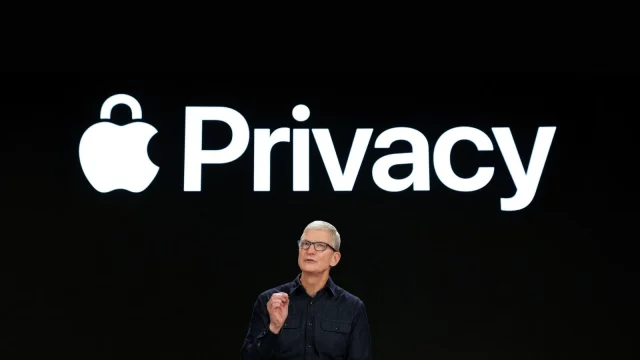 Un homme se tient sur scène devant un grand écran sur lequel s'affiche le mot « Privacy » accompagné du logo Apple en forme de cadenas, soulignant ainsi l'engagement d'Apple en faveur de la confidentialité sur les appareils mobiles.