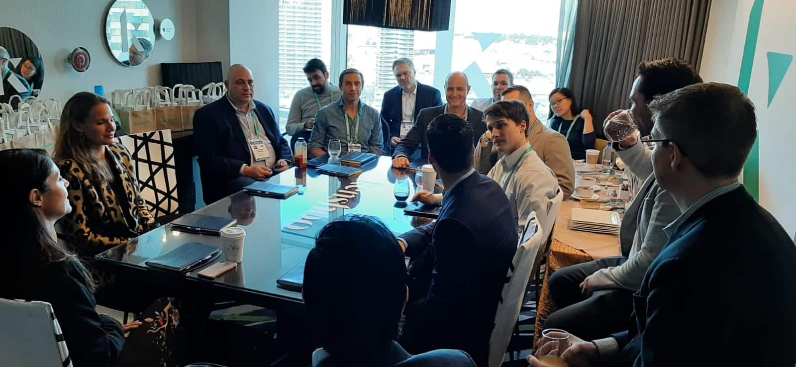 Businesswomen and businessmen gathered in a conference room around a large table at ShopAble 2022.