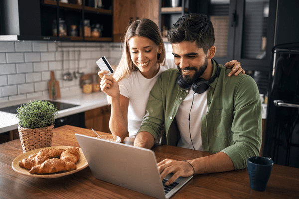 Two friends shopping on their laptop, information that could be included in Skai’s retail media report.