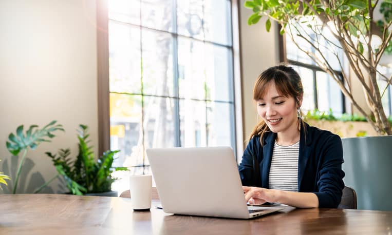 A young business woman learning about Walmart advertising on her laptop.