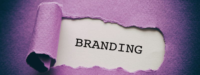 A piece of purple paper is torn back to reveal the word BRANDING written in bold black letters on a white background underneath.