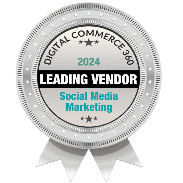 Ein silbernes Abzeichen mit der Aufschrift „Digital Commerce 360, 2024 Leading Vendor, Social Media Marketing“ in der Mitte, umgeben von Sternen und kreisförmigen Mustern, mit zwei Bandenden am unteren Rand.