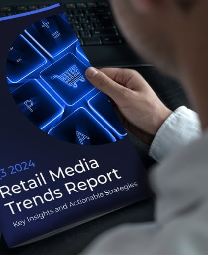 Eine Person hält einen Bericht mit dem Titel „Retail Media Trends Report: Key Insights and Actionable Strategies 2023–2024“ in der Hand, auf dem eine blaue Tastatur mit einer Taste in Form eines Einkaufswagens zu sehen ist, die zukunftsorientierte Einblicke in den Bereich Retail Media für 2025 hervorhebt.