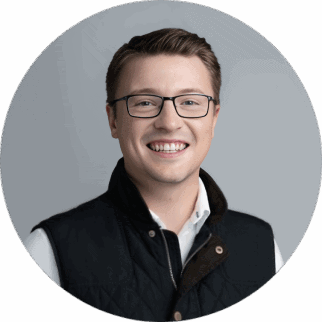 A smiling young man with short brown hair and black-rimmed glasses, wearing a white dress shirt and dark quilted vest, photographed against a gray background in a circular crop—perfect for an omnichannel case study profile.