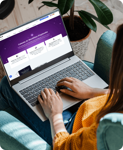 Eine Person in einem gelben Pullover sitzt auf einem Stuhl, hat einen Laptop auf dem Schoß und surft auf einer Website über Celonis AI Workflow Playbooks und Retail Media 2026. Daneben steht eine grüne Topfpflanze.