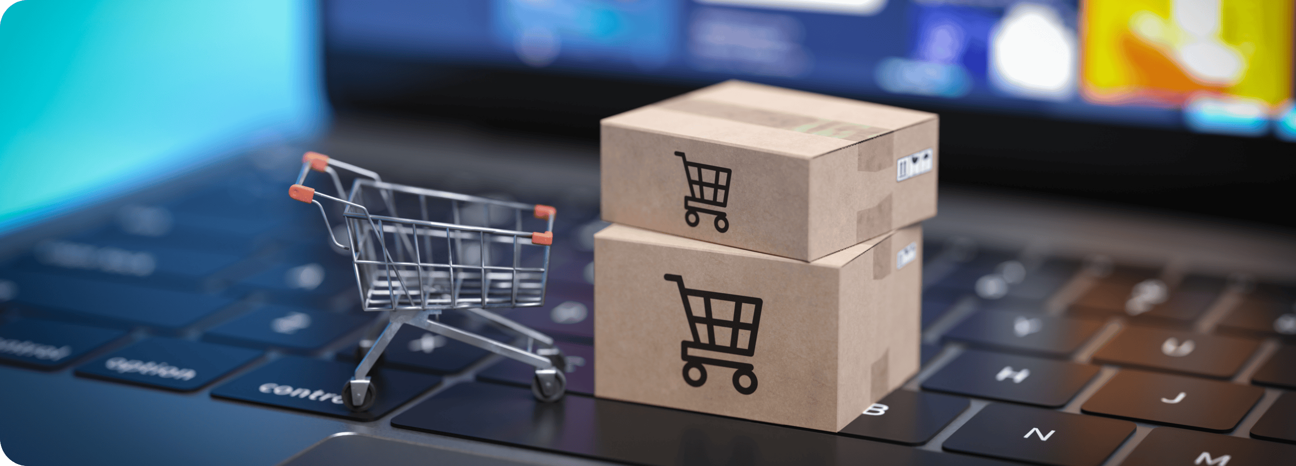 Ein Miniatur-Einkaufswagen und zwei kleine Pappkartons mit Einkaufswagen-Symbolen stehen auf einer Laptop-Tastatur und symbolisieren Online-Shopping oder E-Commerce-Trends, die die Zukunft der Retail-Medien im Jahr 2026 prägen werden.