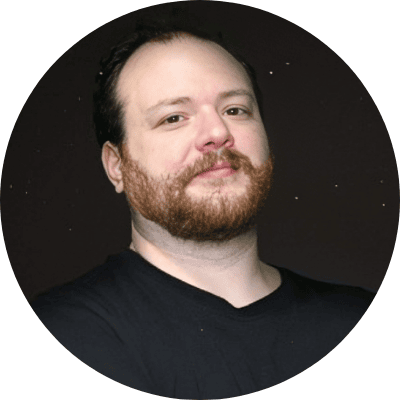 A man with light skin, short dark hair, and a full reddish-brown beard, wearing a black shirt, stands against a dark background, looking at the camera with a slight smile—like the subject of an omnichannel case study.
