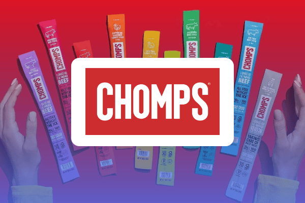 Une paire de mains encadre plusieurs paquets colorés de bâtonnets de viande Chomps disposés à la verticale sur un fond présentant un dégradé rouge et bleu, sur lequel figure le grand logo blanc de Chomps — une image idéale pour mettre en valeur l'étude de cas Chomps Walmart Connect.