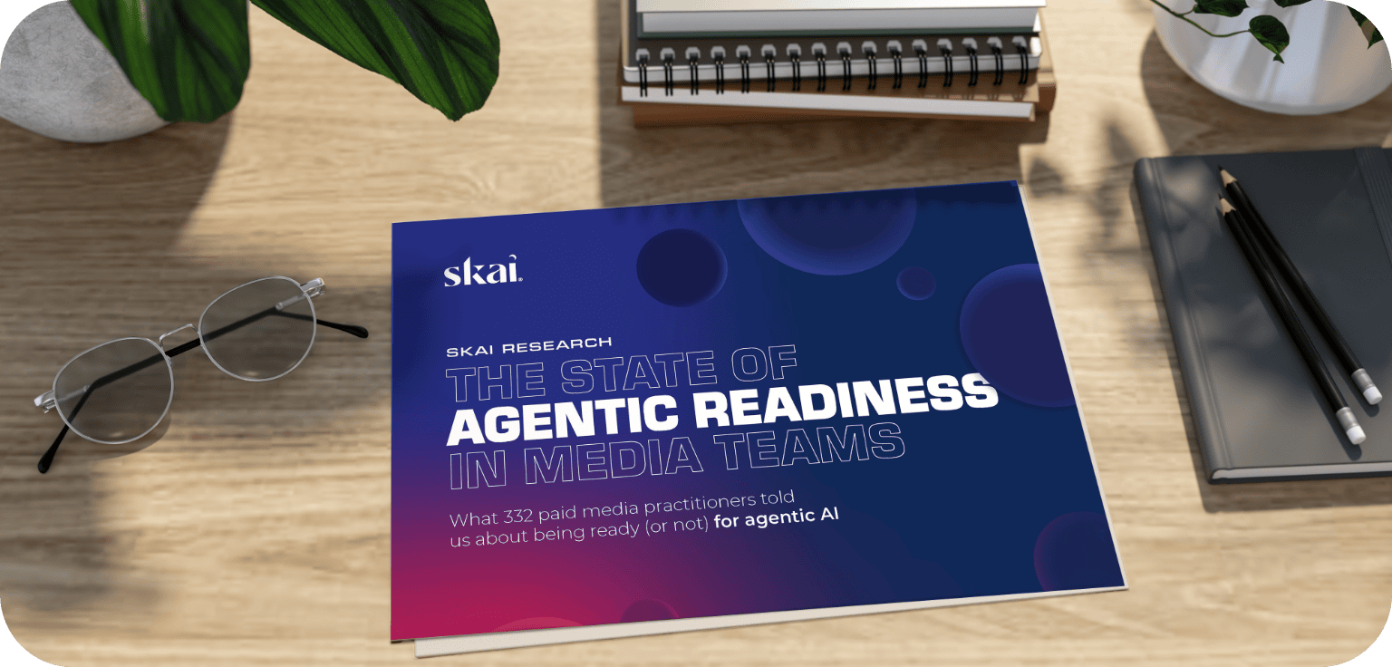 Auf einem Schreibtisch liegt eine Broschüre mit dem Titel „The State of Agentic Readiness in Media Teams“, daneben stehen eine Brille, ein Stift, ein Notizbuch und eine Topfpflanze.